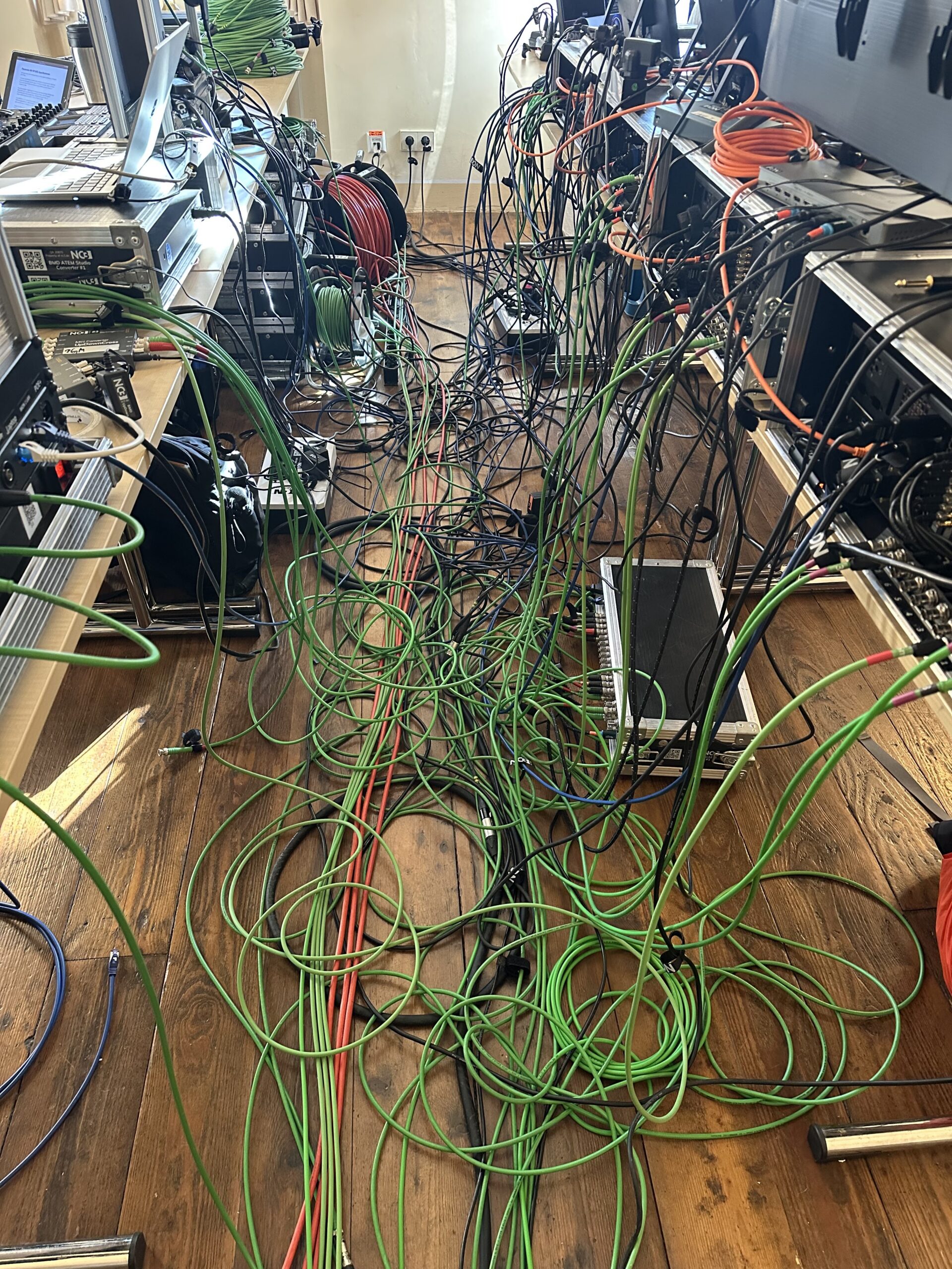 Technisches Backstage-Setup mit unzähligen Kabeln, Servern und Mischpulten für Event-Streaming der NC3 GmbH