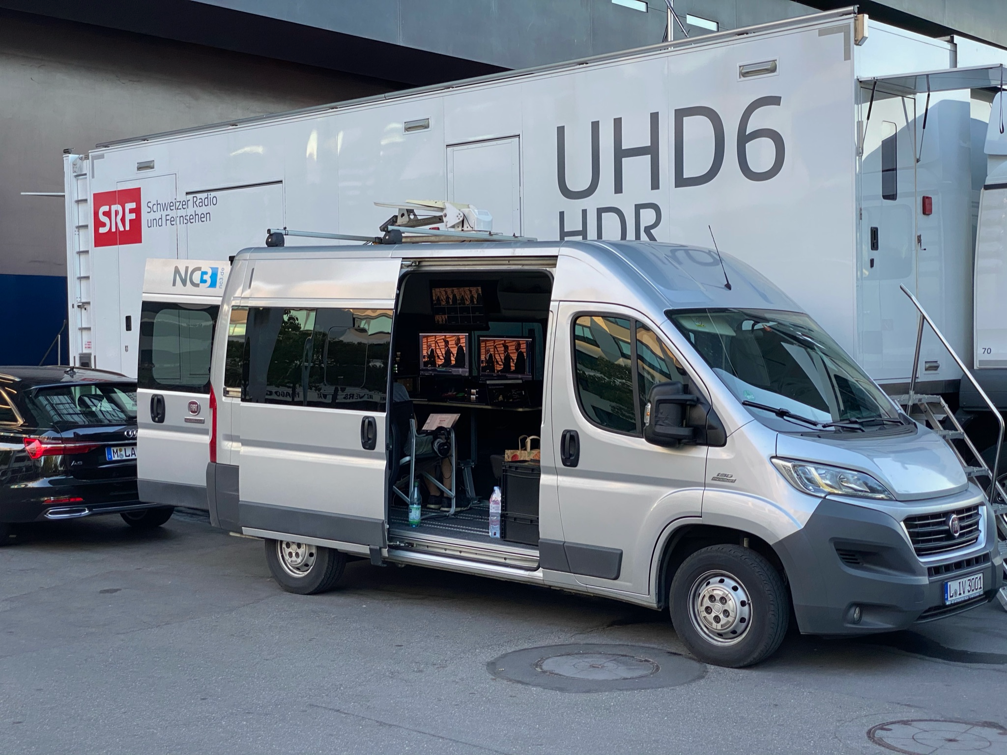 NC3 UHD Livestream Van vor SRF UHD6 HDR Ü-Wagen mit geöffneter Tür und Monitoren